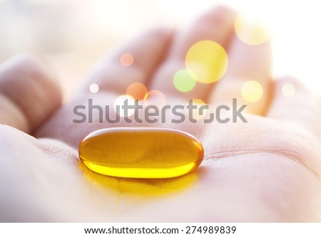 Cod liver oil pill in hand. Magic healing pill.