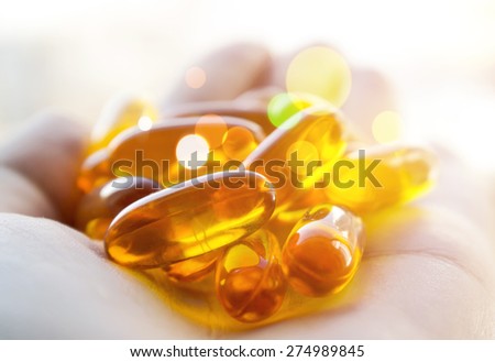 Cod liver oil pills in hand. Magic healing pills.