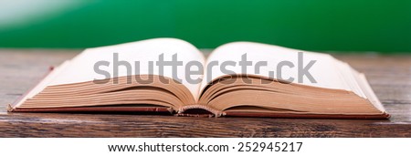 Open book on a green background in a panoramic format