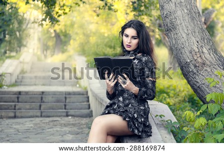 Gothic girl reading a black book