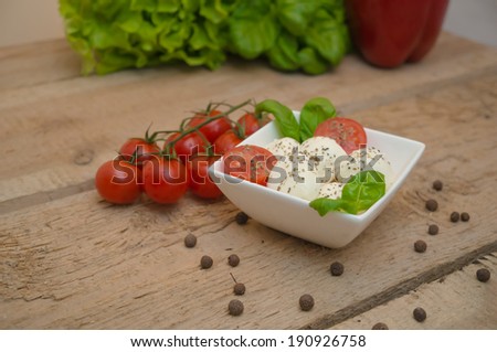Mozzarella cheese in a bowl on a wooden table