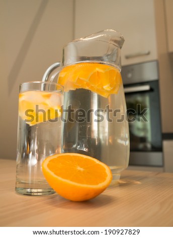 Carafe of water with orange on the kitchen table