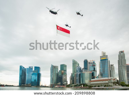 Singapore - August 9, 2014: Singapore National Day helicopter hanging Singapore flag flying over the city