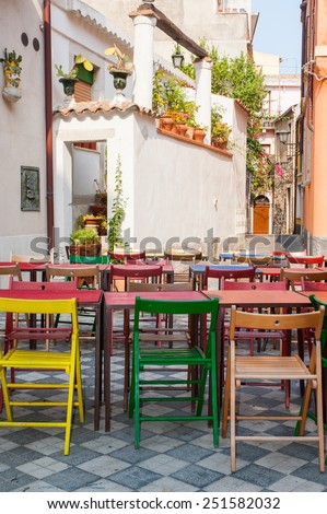 Characteristic colored tables of a Restaurant/pizzeria in the main square of Castelmola, a small touristic village near Taormina