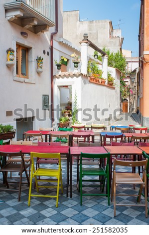 Characteristic colored tables of a Restaurant/pizzeria in the main square of Castelmola, a small touristic village near Taormina