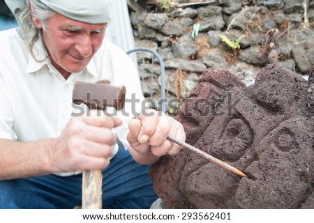 Close up view of a lava stone artist sculpting a lava block