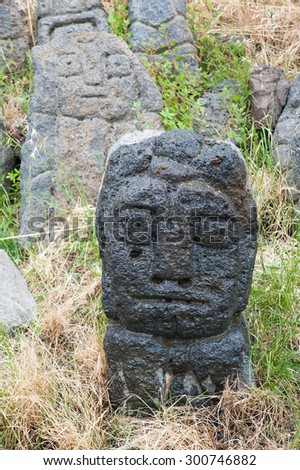 Lava stone sculpture of a man's head poured with water to make its design stand out
