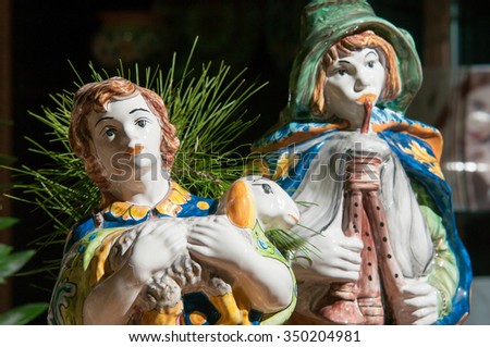 Painted pottery statue portraying a shepherd and his little sheep of a ceramic nativity scene by an artisan in Caltagirone