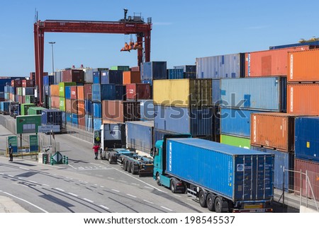 Barcelona, Spain - May 23, 2014: Container Terminal in the port of Barcelona .Pictured trucks carrying containers awaiting appear. You also see a port police and a driver getting into his truck.