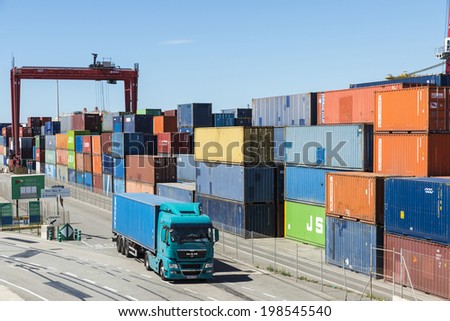 Barcelona, Spain - May 23, 2014: Container Terminal in the port of Barcelona . In the picture a truck carrying containers which is coming out in the terminal appears.