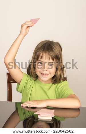 portrait of smiling little girl playing cards