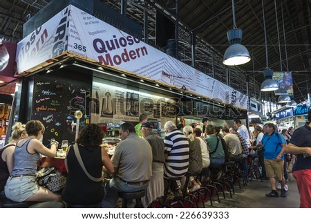 Barcelona, Spain - October 17, 2014: Bar in La Boqueria market with customers sitting in row