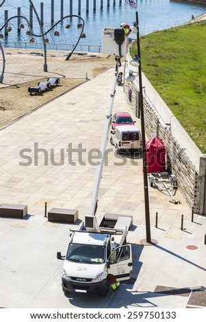 Barcelona, Spain - April 9, 2014: Maintenance worker on a lift repairing the lights in Port Forum in Barcelona.