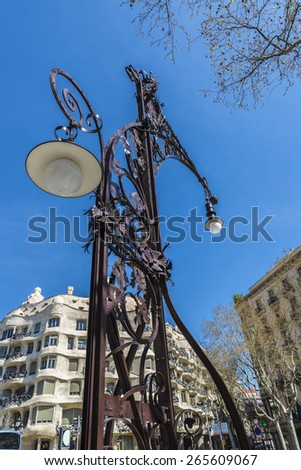 View of Casa Mila, better known as La Pedrera, designed by Antoni Gaudi, and a modernist style streetlight on the Passeig de Gracia, Barcelona, Catalonia, Spain.