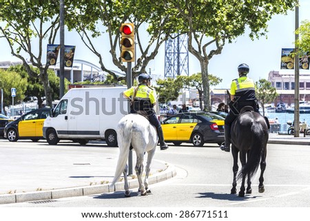Barcelona, Spain - April 21, 2015: City police on horseback in Ramblas. This police force is called Guardia Urbana de Barcelona and one of its functions is to control the traffic in the city