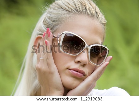 Girl with pony tail and sunglasses blonde in nature