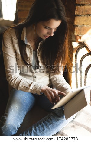 Girl looking at tablet in cafe showing emotion