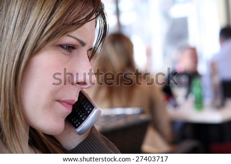 Young woman talking on the mobile phone in a caffe pub