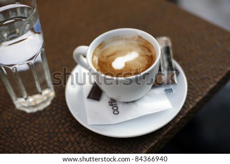 Coffee and glass of water on table