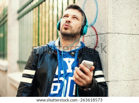 Young man with headphones playing with smart phone