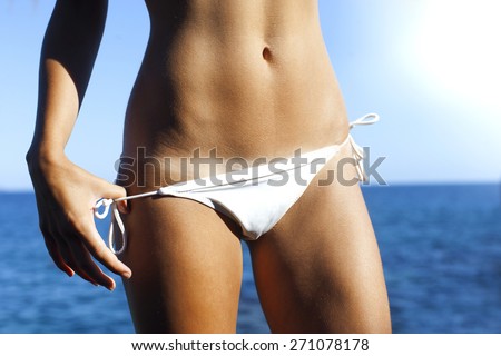 Woman bronze tanned body in summer with bikini line