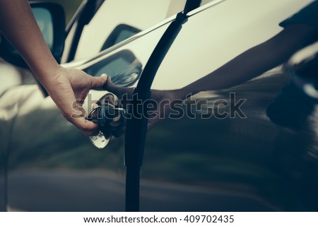 Hand on handle. Close-up of man hand opening a car door. vintage picture style process.