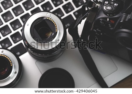 Digital camera, lens and laptop. concept of photographer work station.
