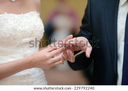 The bride puts the ring on the groom