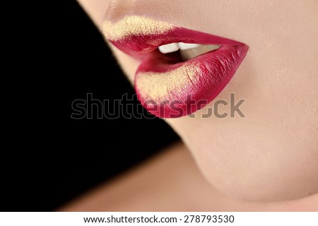 Painted golden lips. Portrait of fashion model girl with perfect bright makeup. Beautiful woman with red glossy lips. Close-up of burgundy lips. Isolated on black background. Open sexy mouth