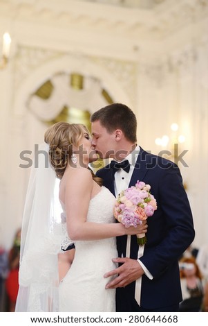 Marriage ceremony. Beautiful sexy model girl in white dress. Wedding couple. Man in suit. Beauty blonde bride with brunette groom. Female and male portrait. Woman with lace veil. Cute lady and guy