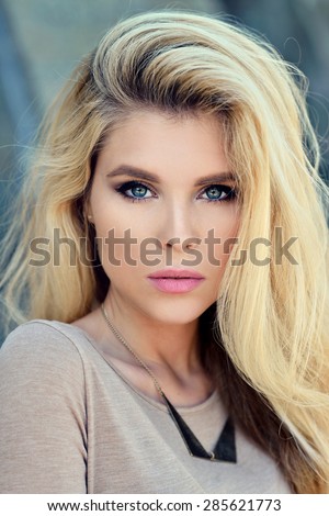 Beautiful blonde woman with long hair. Girl in dress outdoors. Pretty lady on beauty background. Female portrait of sexy fashion model