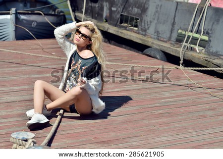 Beautiful blonde woman with long hair. Girl in shorts and t-shirt outdoors. Pretty lady on beauty background. Female portrait of sexy fashion model