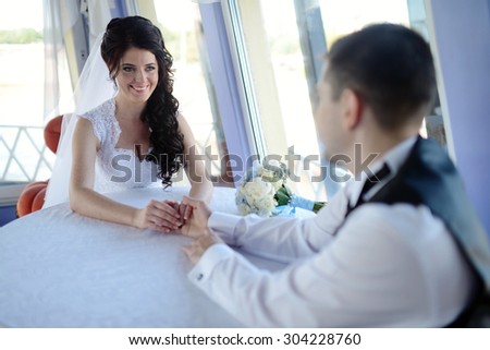 Wedding couple is holding hands. Beauty bride with groom. Beautiful model girl in white dress. Man in suit. Female and male portrait. Woman with lace veil. Cute lady and guy outdoors
