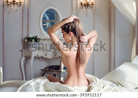 Beautiful nude sexy lady in elegant pose. Portrait of fashion model girl indoors. Beauty blonde woman with attractive buttocks. Close-up female ass and naked body