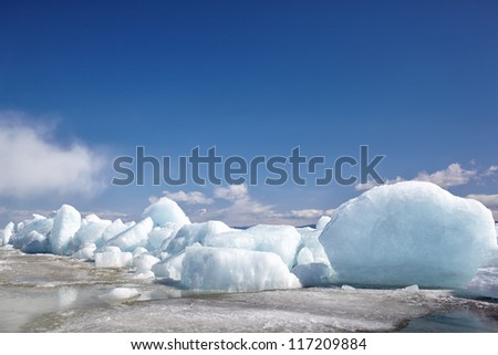 Ice of frozen Baikal lake in winter under blue sky