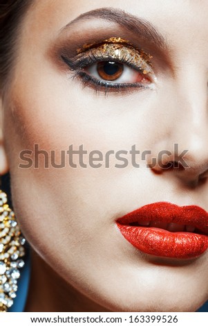 Close-up shot of female face with vogue golden shining eye makeup