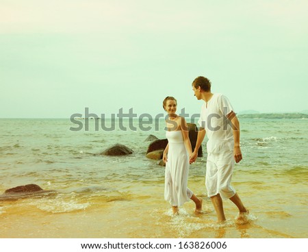 colorized vintage outdoor portrait of young romantic couple in white cotton clothes on beach of Phuket island, Thailand