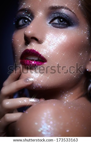 Low depth of focus portrait of beautiful young woman with vogue shining sparkle face makeup