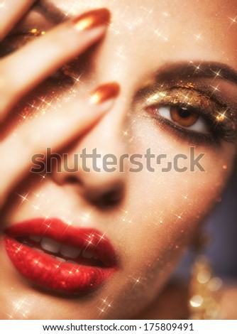 Soft focus portrait of beautiful young woman with shining face makeup and hands on face