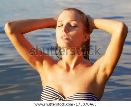 portrait of young beautiful blonde woman in sea waters