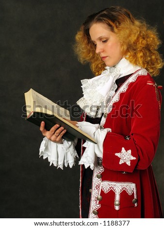 Woman dressed in old-fashioned french clothes of 18 century reading a book