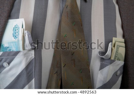 Man in suit with money in his pockets