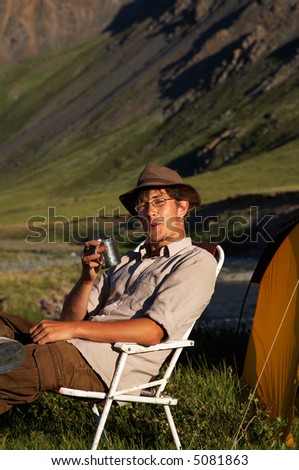 man sitting in the chair at the camp in mountains