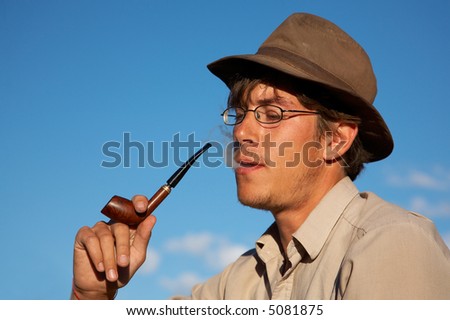 man in hat is smoking tobacco-pipe