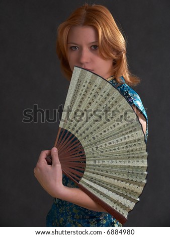 Young girl with fan isolated on the black background