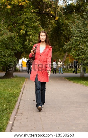Girl walking along footpath and eating chocolate ice cream