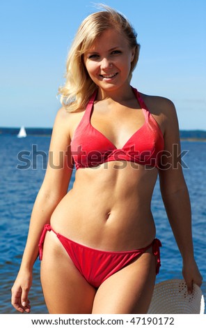 beautiful slvonic blonde girl posing in red bikini in the sea waters