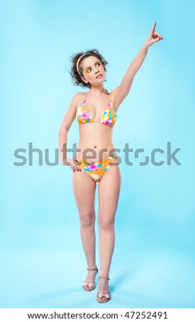 portrait of beautiful slavonic girl posing in bikini points on right-top corner of frame