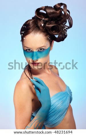 portrait of beautiful girl with blue stripe facial bodyart and fantasy hair-do with several thin braids