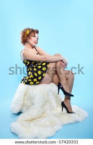 portrait of girl dressed and maked up in retro style posing on white fur